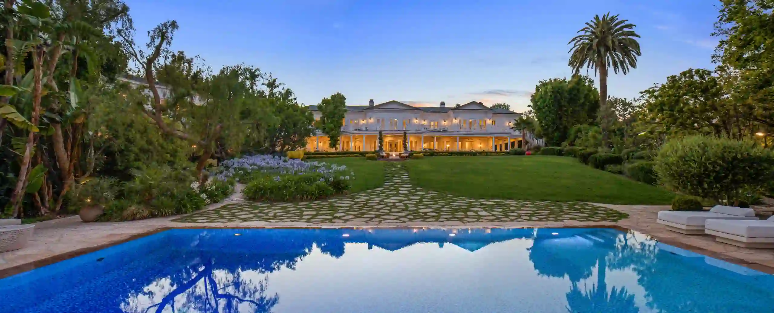 Maison Du Soleil estate at dusk, viewed across the reflecting pool